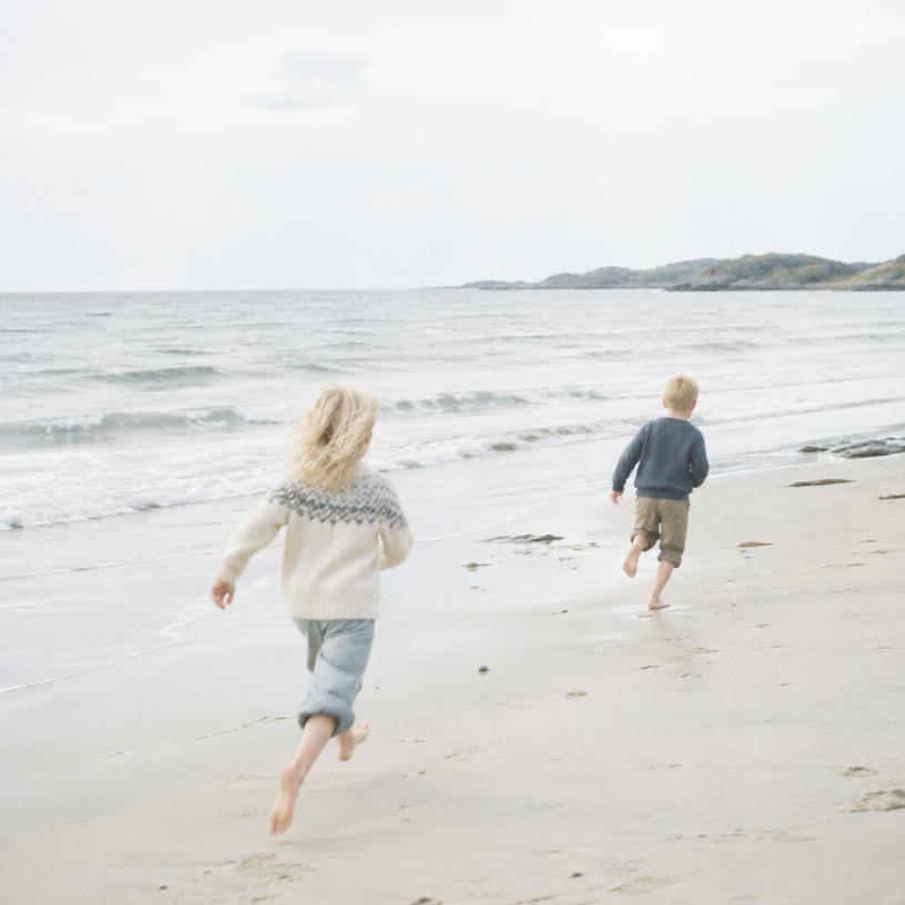 Children running along a nordic beach